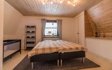 Schlafzimmer mit Doppelbett und Babybett Ferienhaus Hällefors