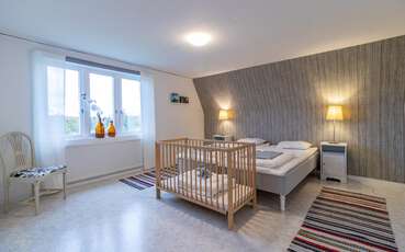 Schlafzimmer mit zwei Einzelbetten und Babybett Ferienhaus Boda