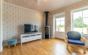 Wohnzimmer mit TV und Kamin Ferienhaus Friedas hus