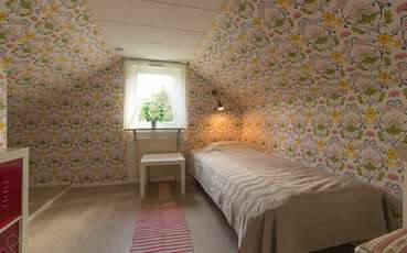 Schlafzimmer mit einem Einzelbett Ferienhaus Hjorten