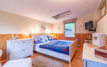 Schlafzimmer mit Doppelbett und TV Ferienhaus Lillebo