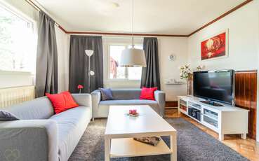 Wohnbereich mit Couch und TV Ferienhaus Lönneberga