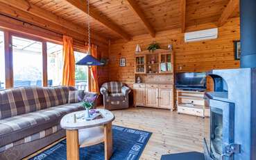 Wohnbereich mit TV und Kamin Ferienhaus Norrland