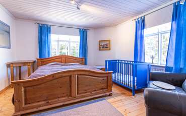 Schlafzimmer mit Doppelbett und Babybett Ferienhaus Solberga