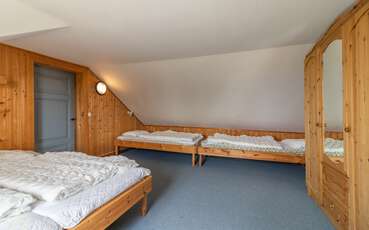 Schlafzimmer mit einem Doppelbett und zwei Einzelbetten Ferienhaus Waldschule
